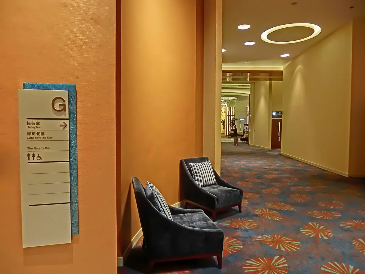 Bewegwijzeringspaneel in een hotelgang met toilet- en rolstoelpictogrammen